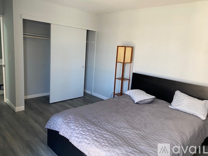 A bedroom with a bed, pillows, and a wooden ladder.