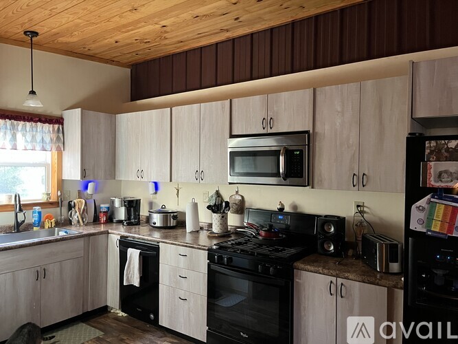 A kitchen with wooden cabinets and a black stove top oven.