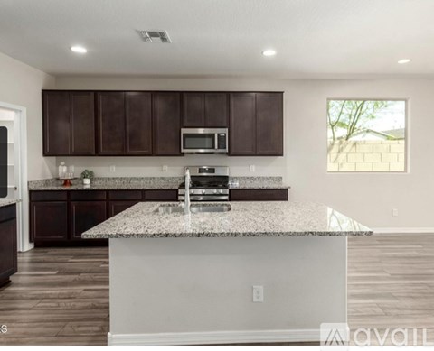 A kitchen with brown cabinets and a granite countertop.