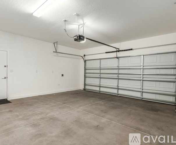 A spacious garage with a white door and a grey floor.