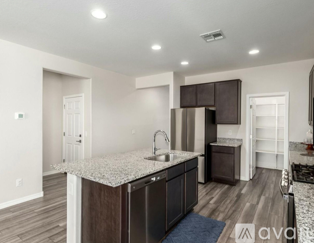 A kitchen with a granite countertop and wooden cabinets.