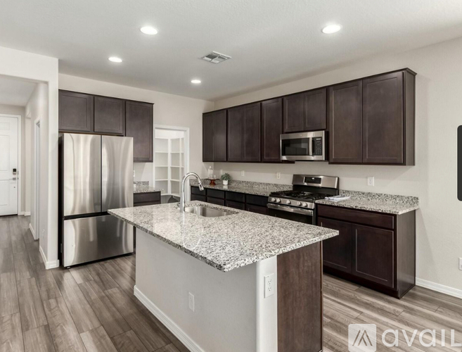 A kitchen with a granite countertop and stainless steel appliances.