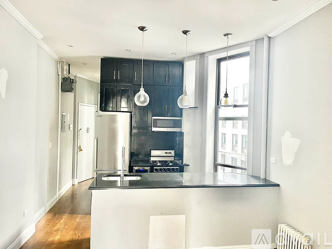 A modern kitchen with a black countertop and white cabinets.