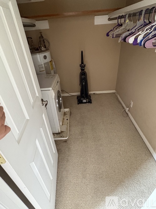 A laundry room with a washer and dryer and a vacuum cleaner.
