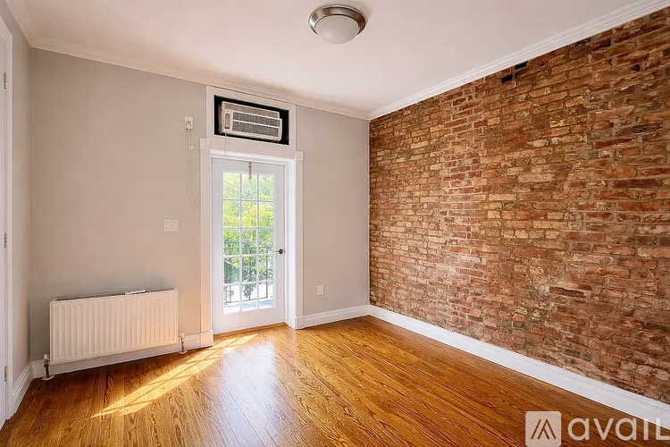 A room with a brick wall and wooden flooring.