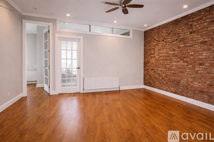 A room with wooden floors and a brick wall.