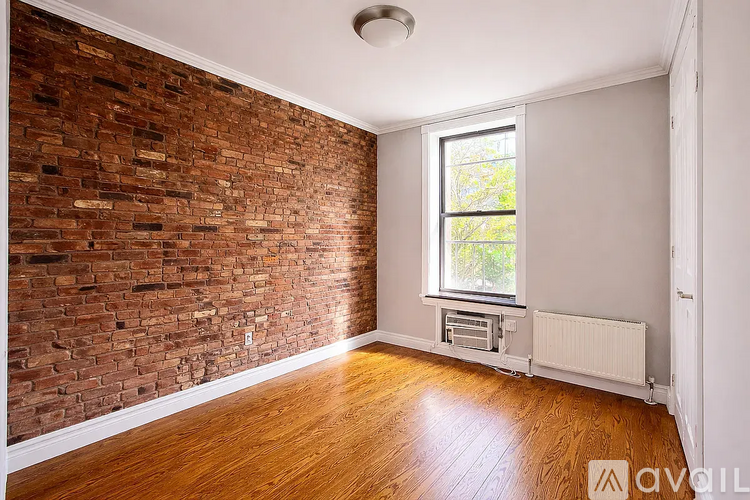 A room with a brick wall and wooden floor.