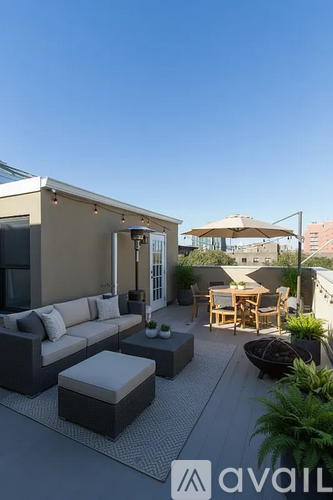 A modern outdoor living space with a couch, chairs, and a table.