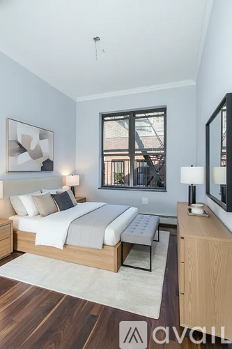 A bedroom with a large bed and a window overlooking a balcony.