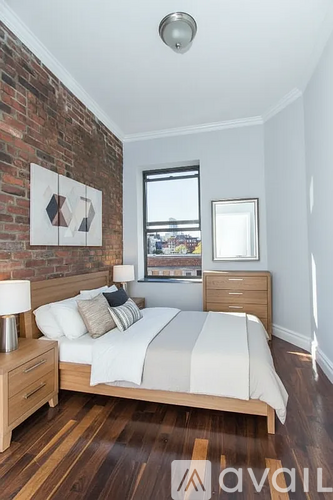 A bedroom with a brick wall and a large bed.