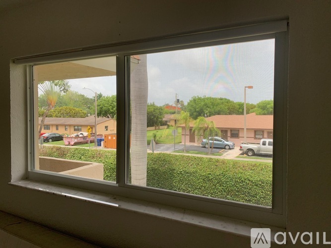 A window with a view of a residential area outside.