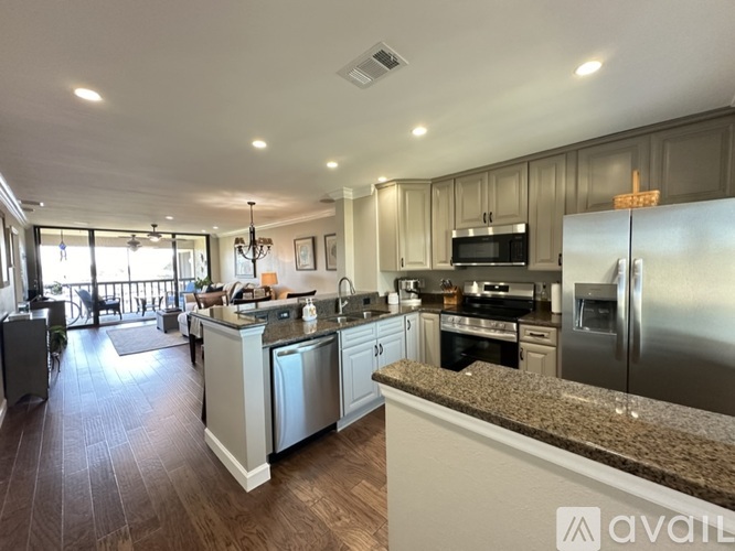 A kitchen with a refrigerator, sink, and oven.