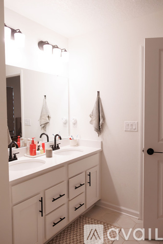 A bathroom with a sink, mirror, and towel rack.