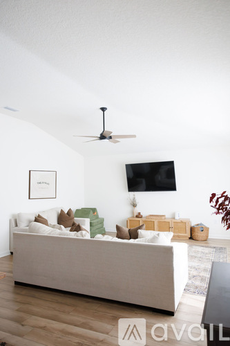 A living room with a white couch and a ceiling fan.