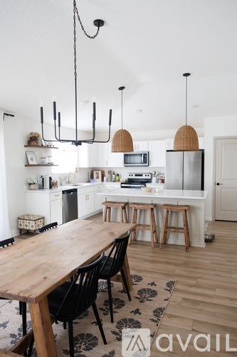 A kitchen with a wooden table and chairs.