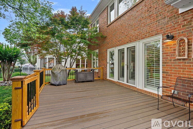 A wooden deck with a bench and a table is surrounded by trees.
