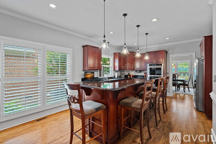 A kitchen with wooden chairs and a table with a countertop.
