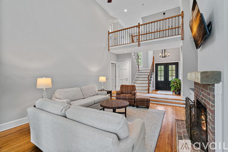 A living room with a grey couch and a fireplace.