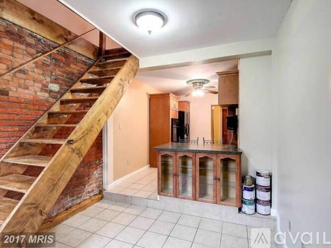 A room with a staircase and a cabinet with glass doors.