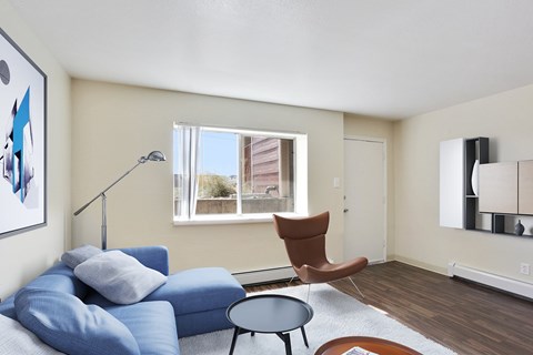 A living room with a blue couch and a brown chair.