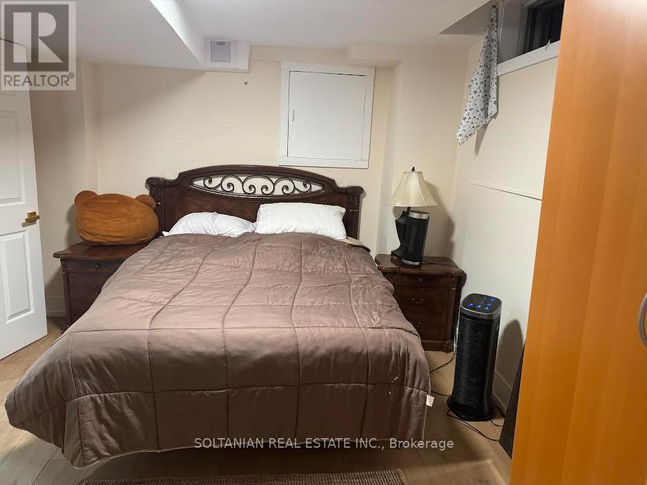 A bedroom with a bed, nightstand, and lamp.
