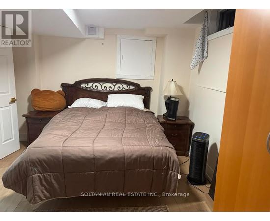 A bedroom with a bed, nightstand, and lamp.