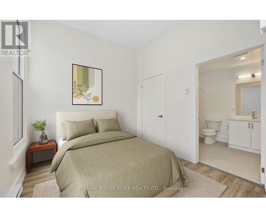 A bedroom with a bed, nightstand, and a framed picture on the wall.
