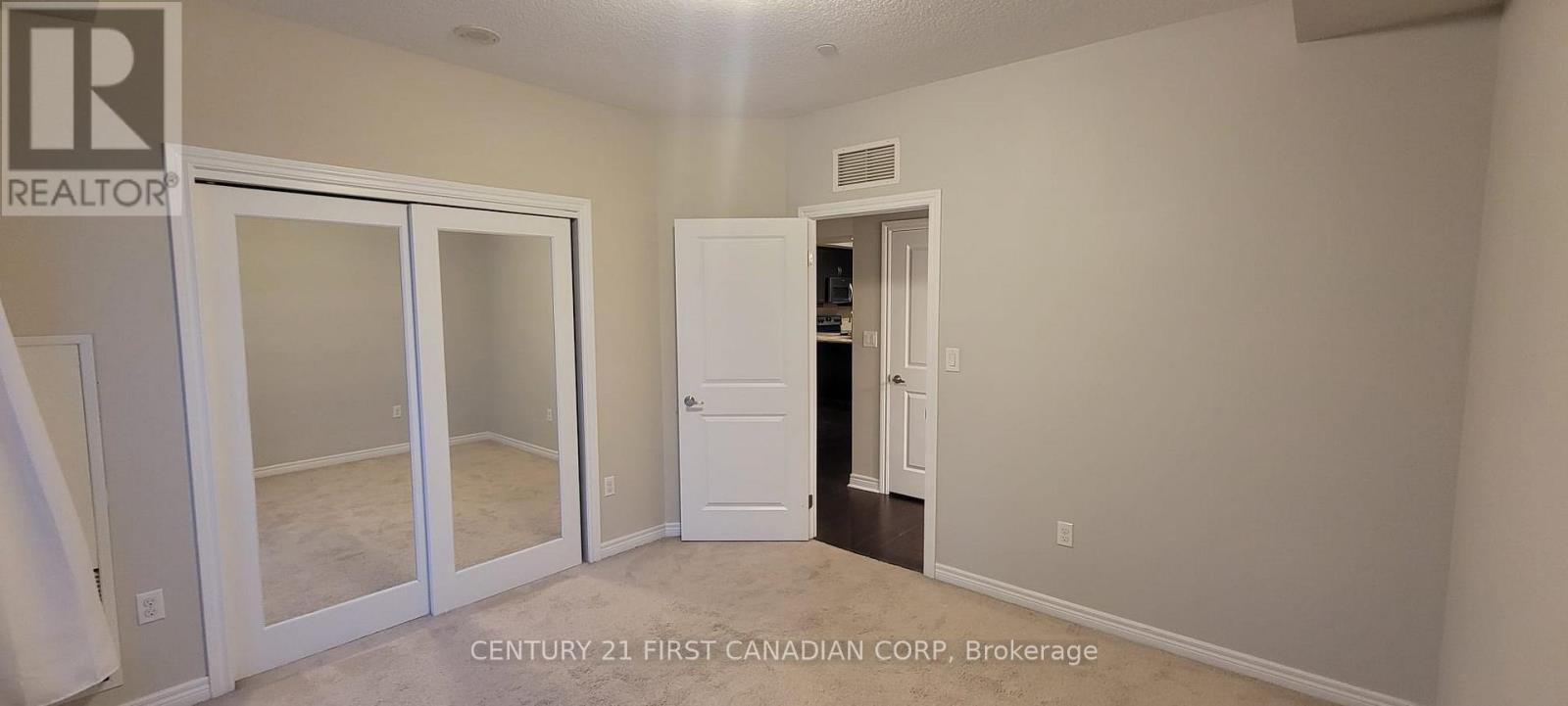 A bedroom with a white door and a white wall.