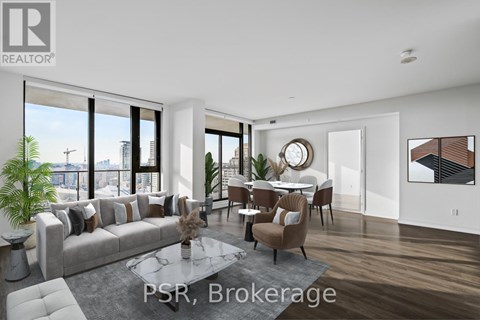 A modern living room with a grey sofa and a glass table.