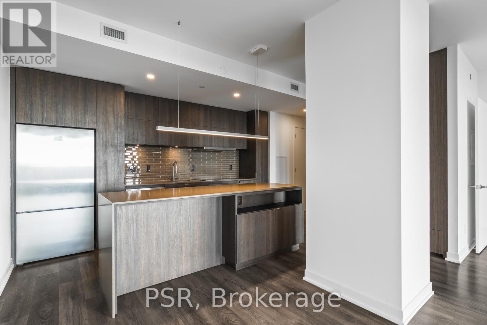 A modern kitchen with a refrigerator and a countertop.
