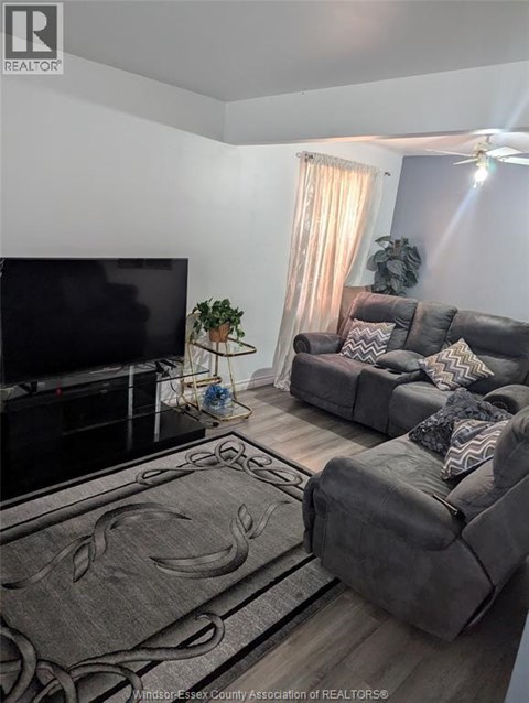 A living room with a grey couch and a flat screen TV.
