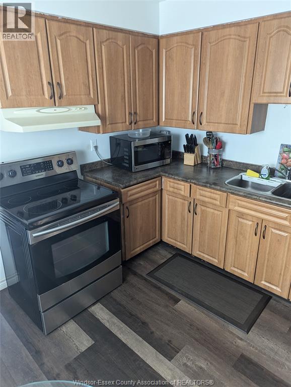 A kitchen with wooden cabinets and a black stove top oven.