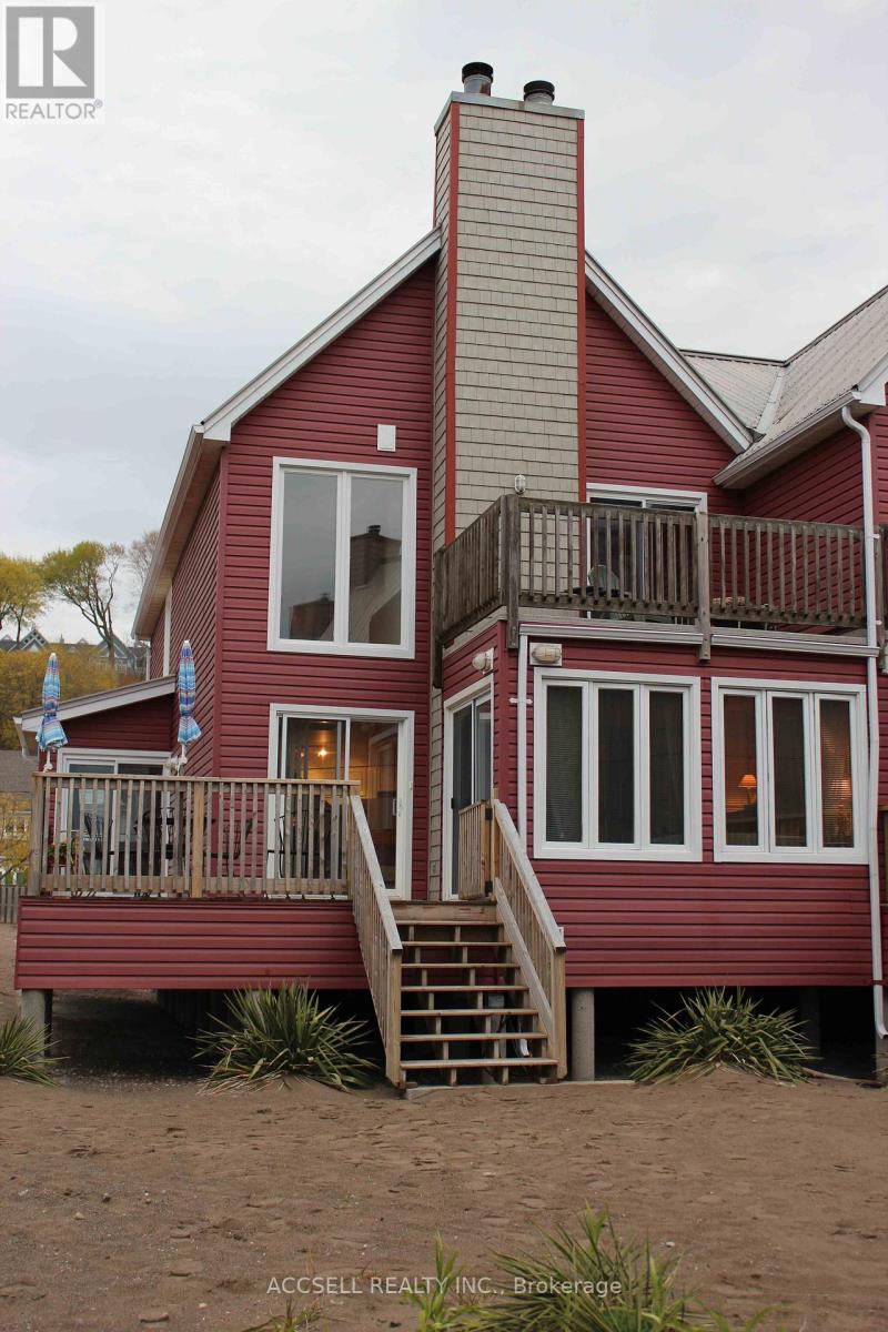 A red house with a balcony and a staircase leading to the second floor.