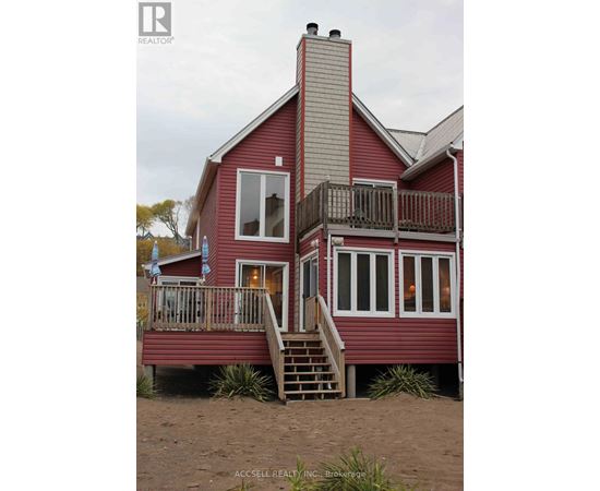 A red house with a balcony and a staircase leading to the second floor.