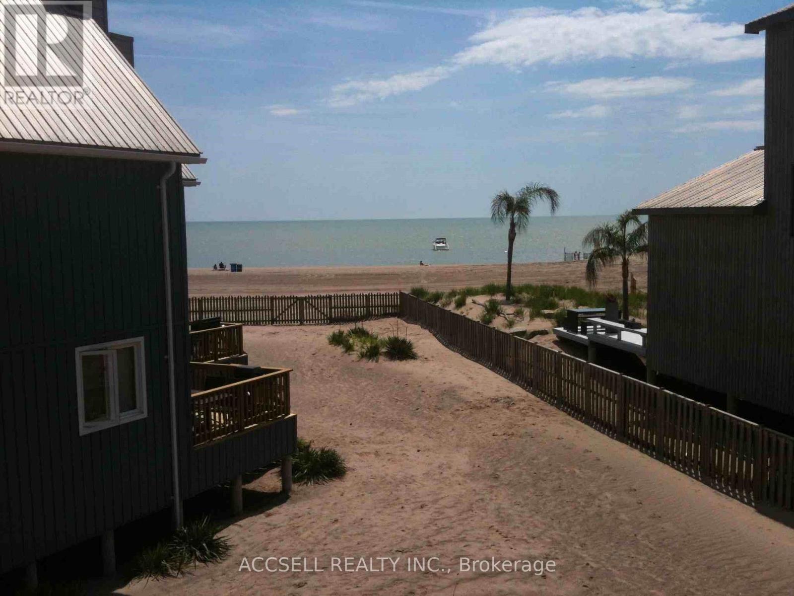 A beachfront property with a view of the ocean and a boat in the distance.