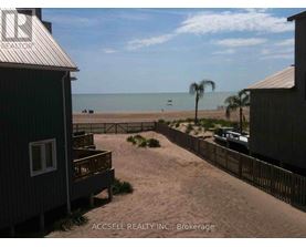 A beachfront property with a view of the ocean and a boat in the distance.