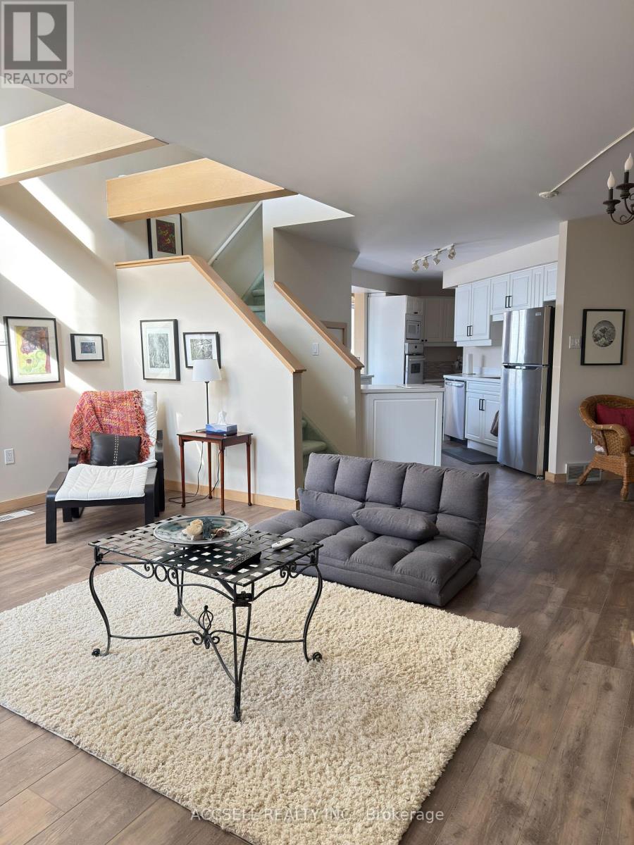 A living room with a grey couch and a glass table.