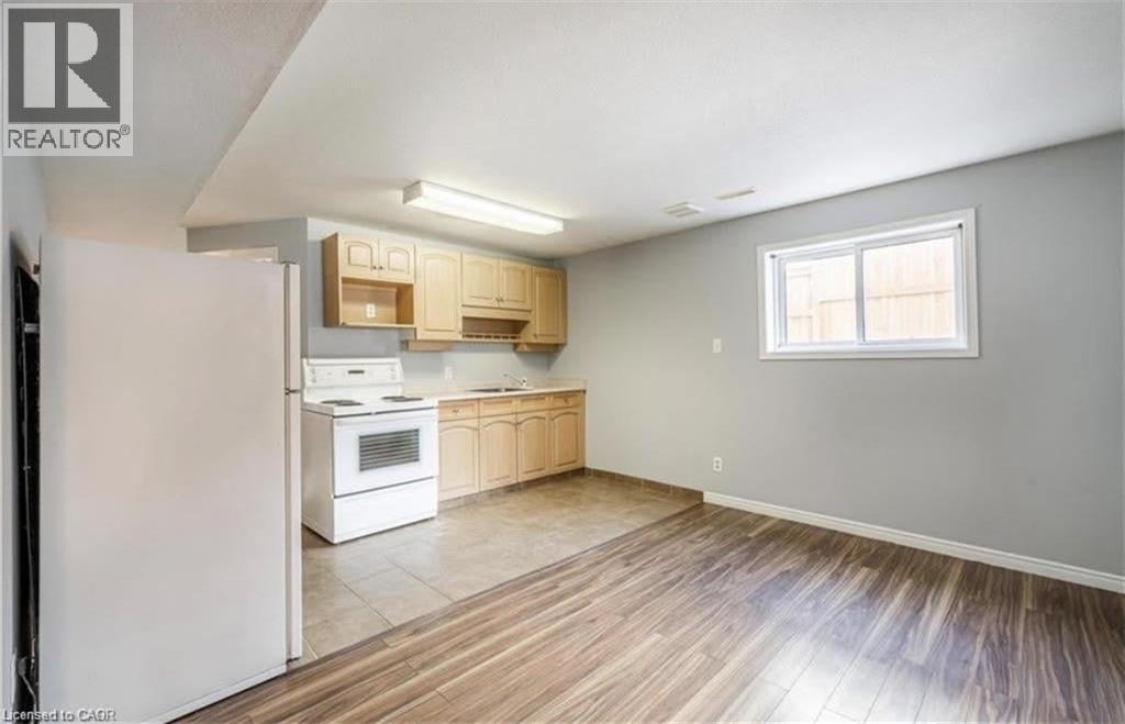 A kitchen with wooden floors and a white refrigerator.