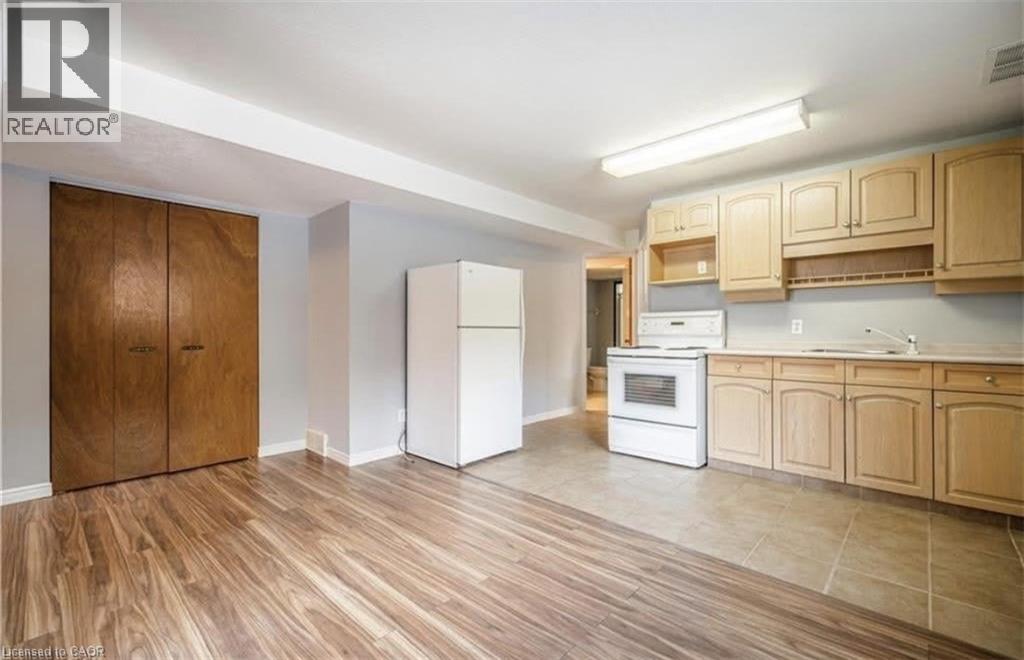 A kitchen with wooden floors and cabinets.