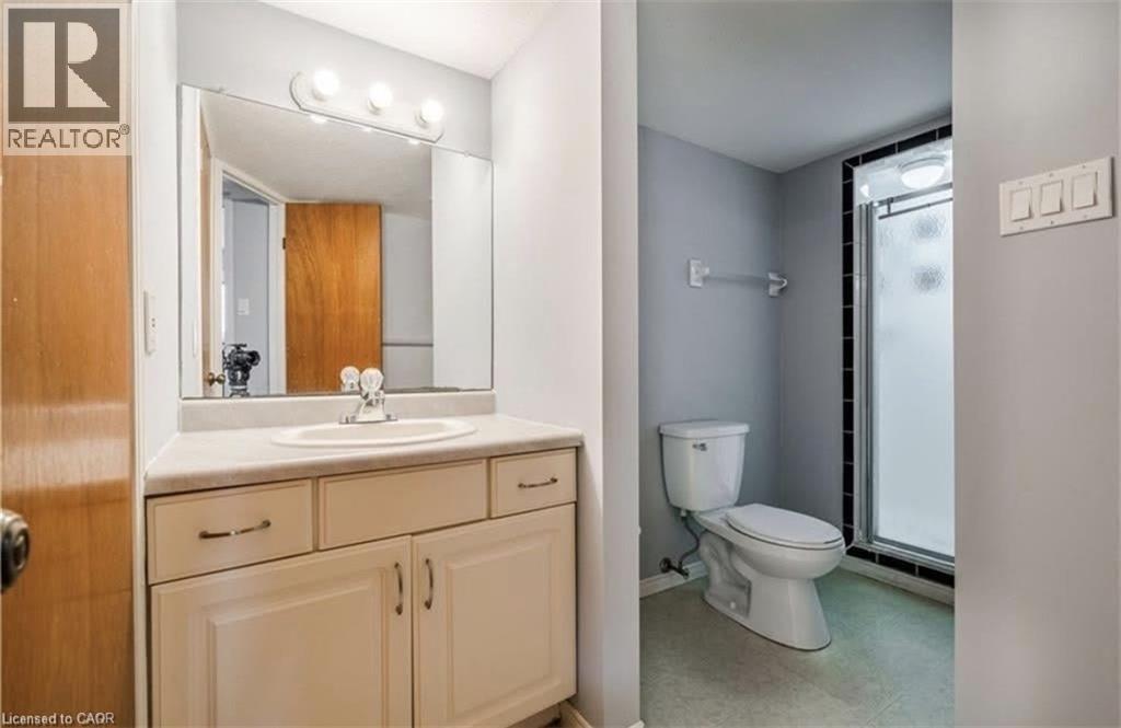 A bathroom with a toilet, sink, and mirror.