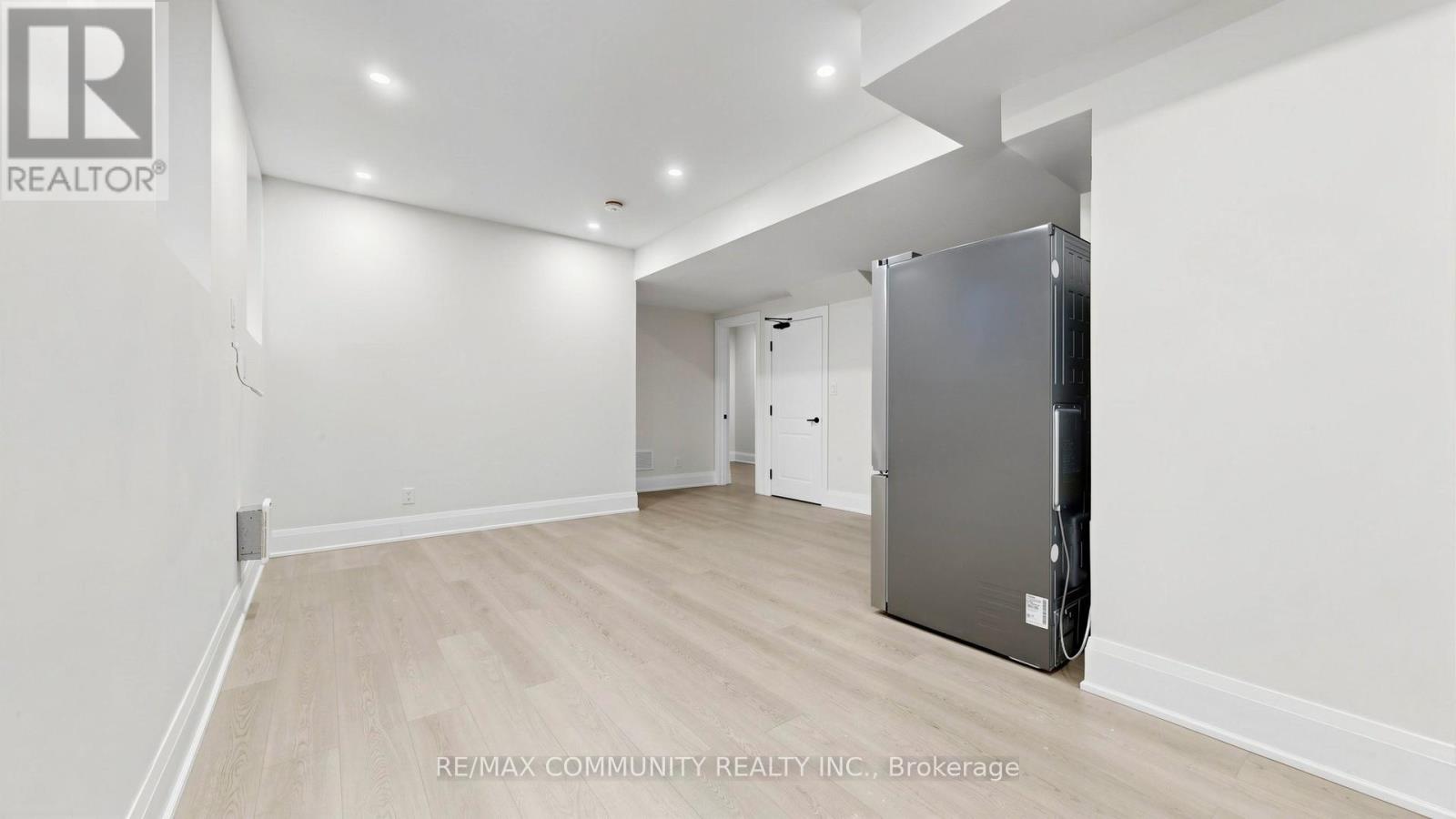 A spacious room with a refrigerator in the corner.