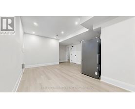 A spacious room with a refrigerator in the corner.