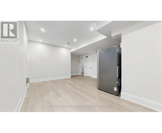 A spacious room with a refrigerator in the corner.
