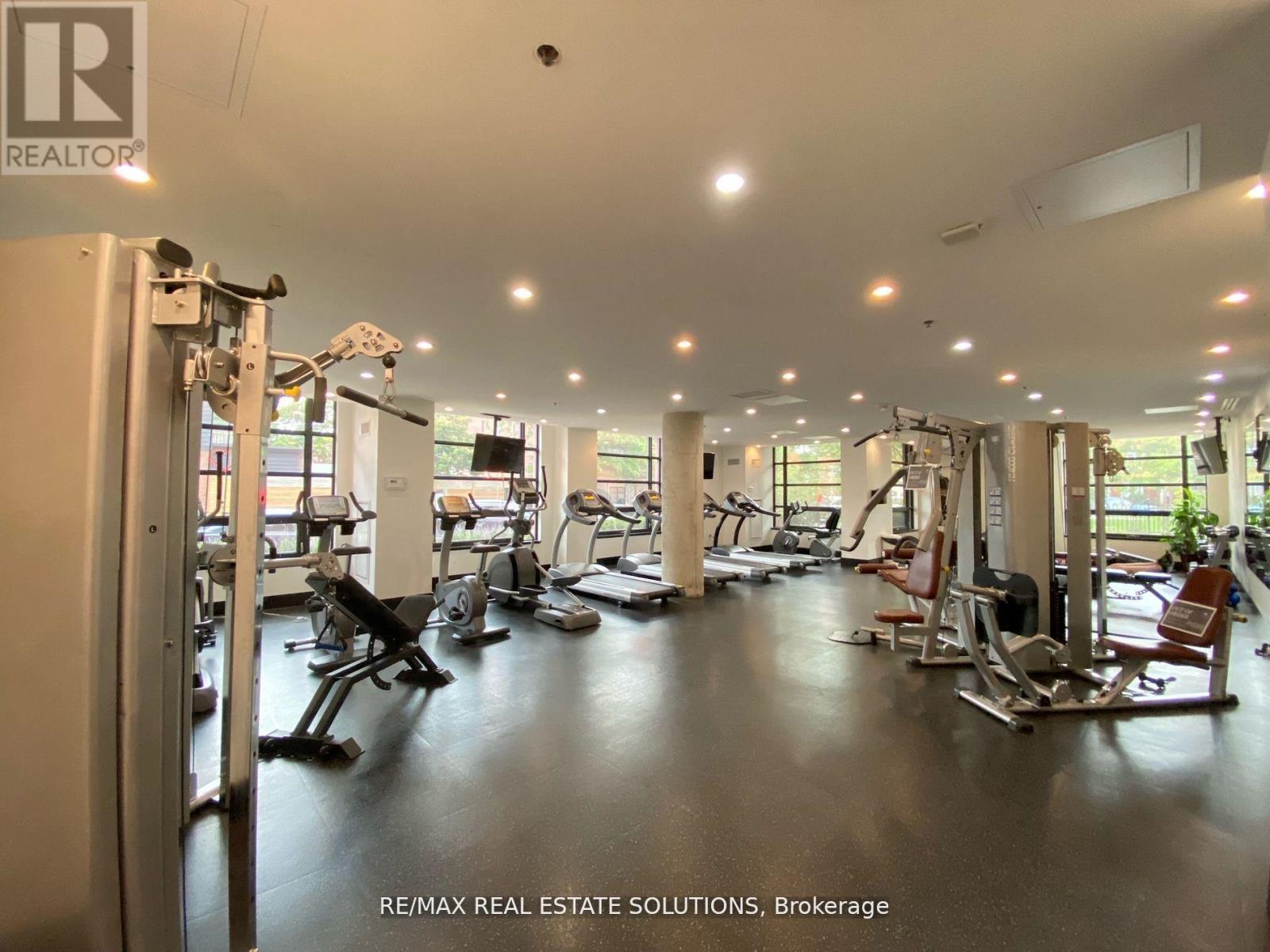 A gym with a variety of equipment including treadmills, weights, and exercise machines.