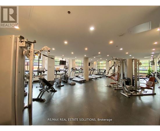 A gym with a variety of equipment including treadmills, weights, and exercise machines.