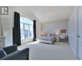 A bedroom with a large bed and a grey couch.