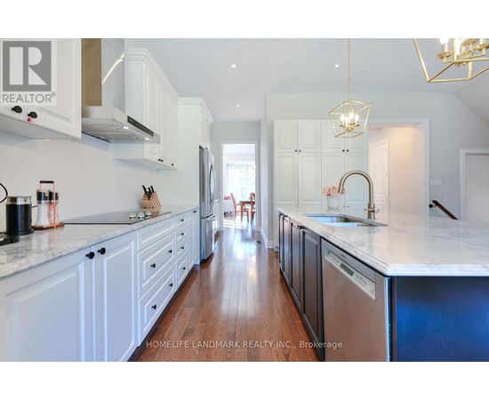 A kitchen with white cabinets and a marble countertop.