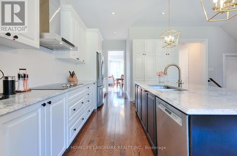 A kitchen with white cabinets and a marble countertop.