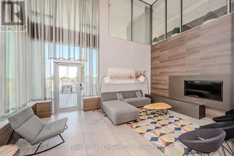 A living room with a grey couch and a wooden fireplace.