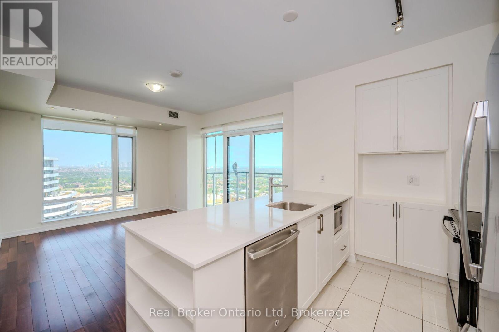 A kitchen with white cabinets and a large island.